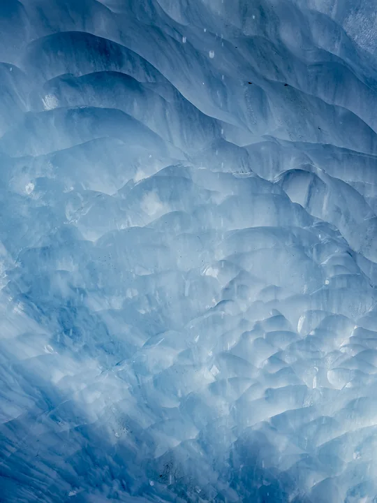 Les courbes et les creux bleutés de la glace remplissent le cadre.
