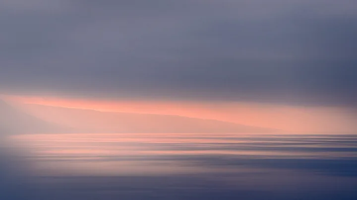 Des lignes d’eau et de ciel dessinent un paysage doux, bleu et rose.