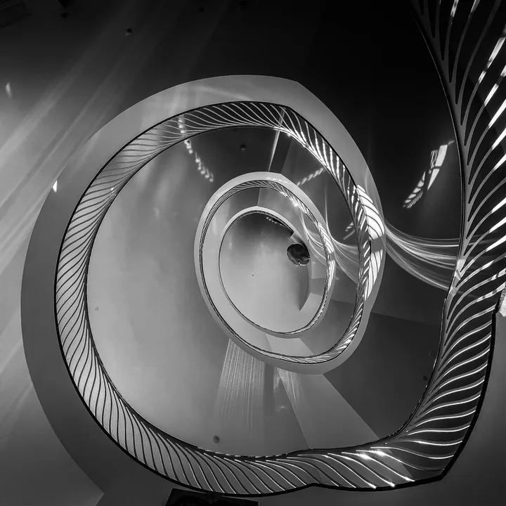 Un escalier en spirale dessine plusieurs courbes vues d’en haut.